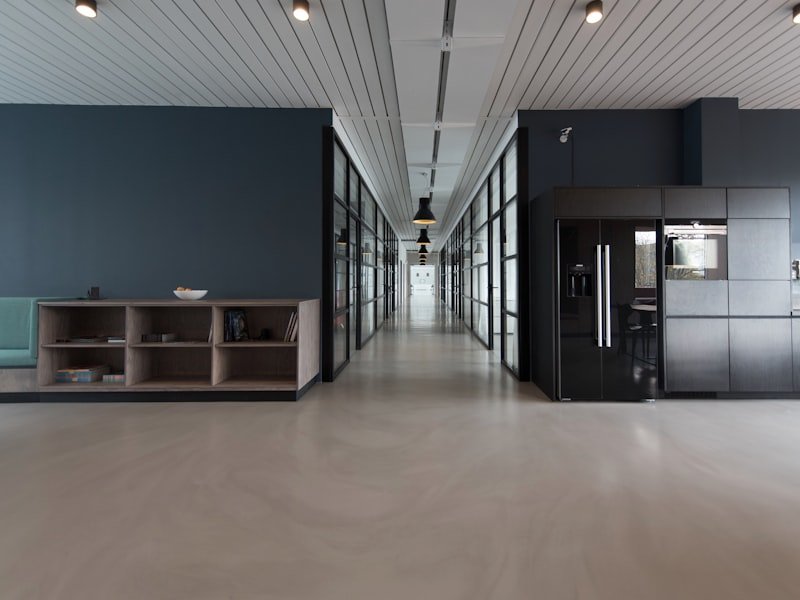 Modern Winnipeg office renovation with polished concrete floors, glass partitions, and dark accent walls