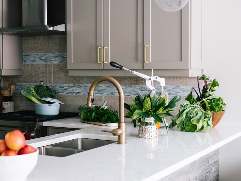 Custom Winnipeg millwork detail with taupe shaker cabinetry, brass faucet, and handcrafted wood counter stools